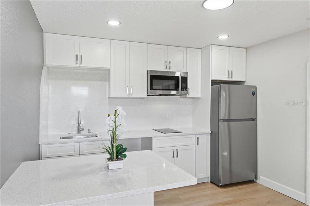 3454 Rambler Avenue St. Cloud, FL 34772 - Photo 13 of 24 a kitchen with stainless steel appliances a refrigerator sink and cabinets