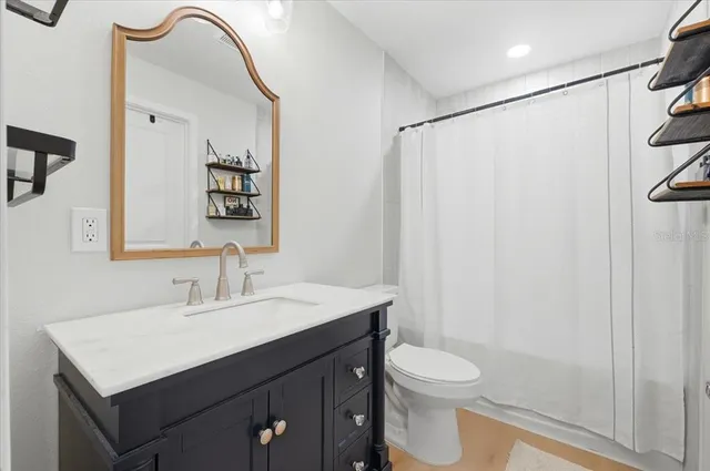 a bathroom with a sink vanity mirror and toilet