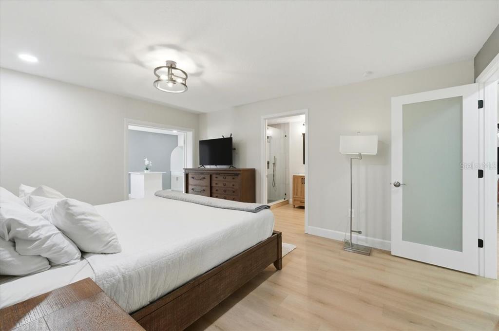 3454 Rambler Avenue St. Cloud, FL 34772 - Photo 8 of 24 a spacious bedroom with a bed and a chandelier