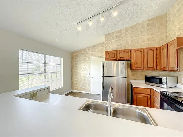 a kitchen with a sink a refrigerator and cabinets