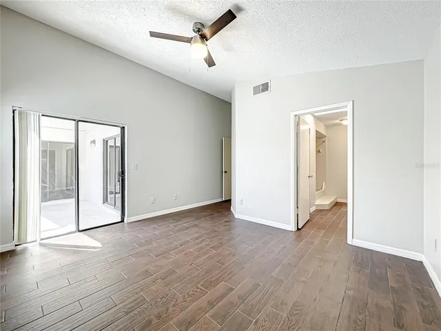 a spacious bathroom with a granite countertop sink a toilet and a mirror