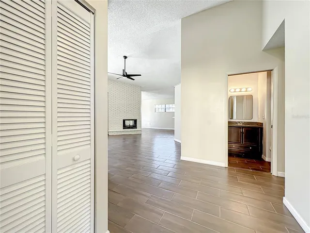 a view of a hallway view with wooden floor and a bathroom