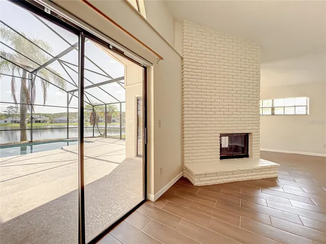 a view of a livingroom with wooden floor and a fireplace