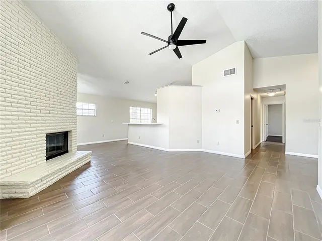 a view of empty room with wooden floor and window