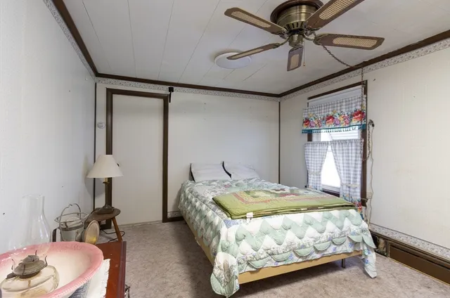 a bedroom with a bed a chandelier and a mirror