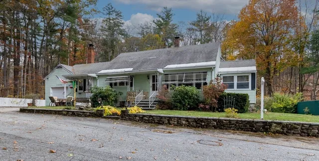 a front view of a house with a garden and sitting area