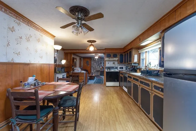 a kitchen with stainless steel appliances kitchen island granite countertop a table chairs and a chandelier