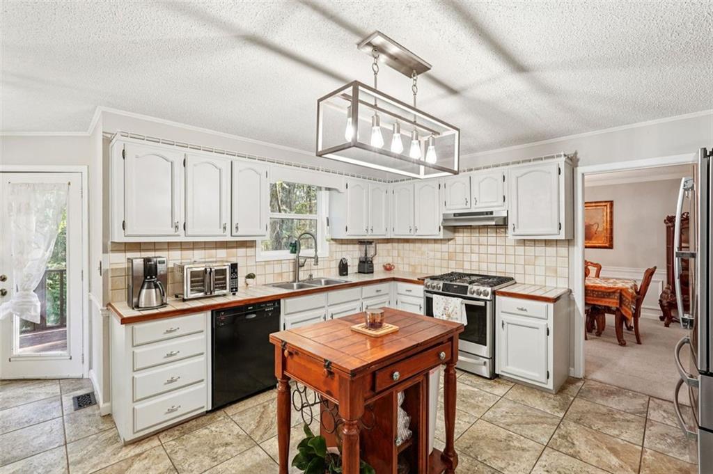 39 Hampton Way Carrollton, GA 30116 - Photo 14 of 57 a kitchen with stainless steel appliances granite countertop a stove a sink dishwasher and a refrigerator with white cabinets