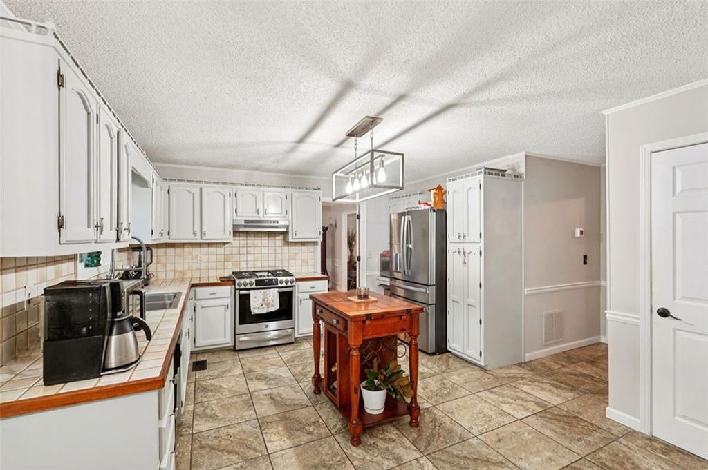 39 Hampton Way Carrollton, GA 30116 - Photo 15 of 57 a kitchen with stainless steel appliances granite countertop a stove refrigerator and cabinets