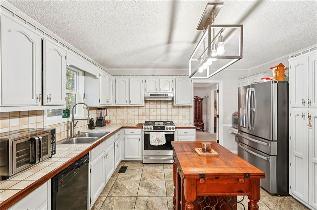 39 Hampton Way Carrollton, GA 30116 - Photo 16 of 57 a kitchen with stainless steel appliances granite countertop a refrigerator a stove and white cabinets