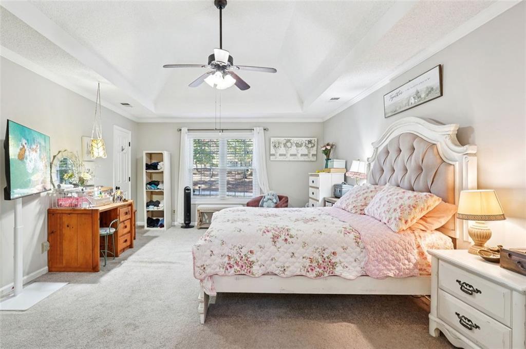 39 Hampton Way Carrollton, GA 30116 - Photo 29 of 57 a bedroom with a large bed and a chandelier