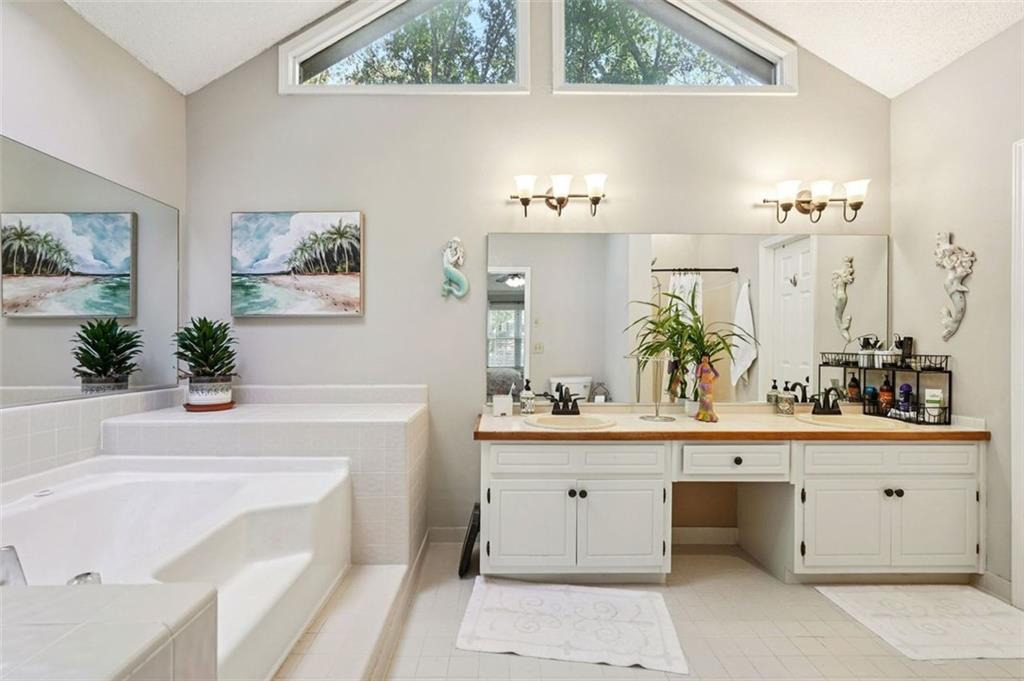 39 Hampton Way Carrollton, GA 30116 - Photo 32 of 57 a bathroom with a bathtub a sink and a potted plant