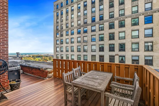 a view of a roof deck with couches and wooden floor