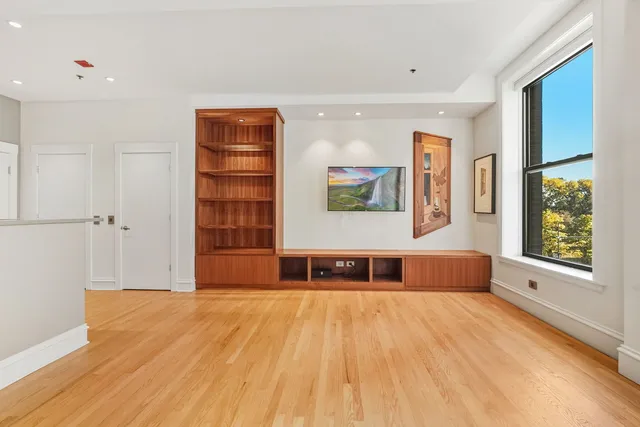 a view of a bedroom with wooden floor and windows