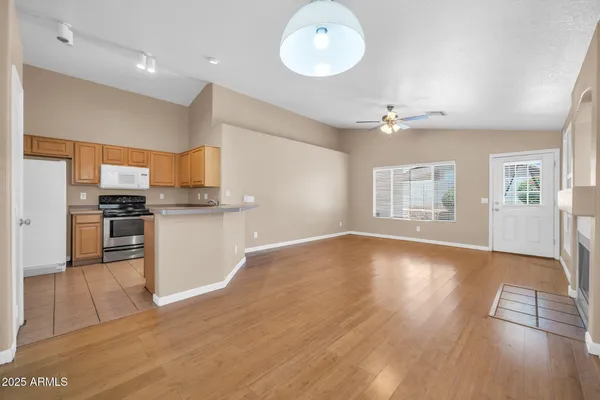 a view of a livingroom with wooden floor and a ceiling fan