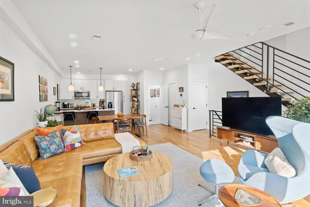a living room with furniture kitchen view and a table