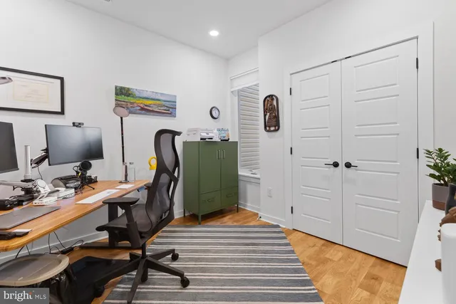 a view of a workspace with furniture and wooden floor