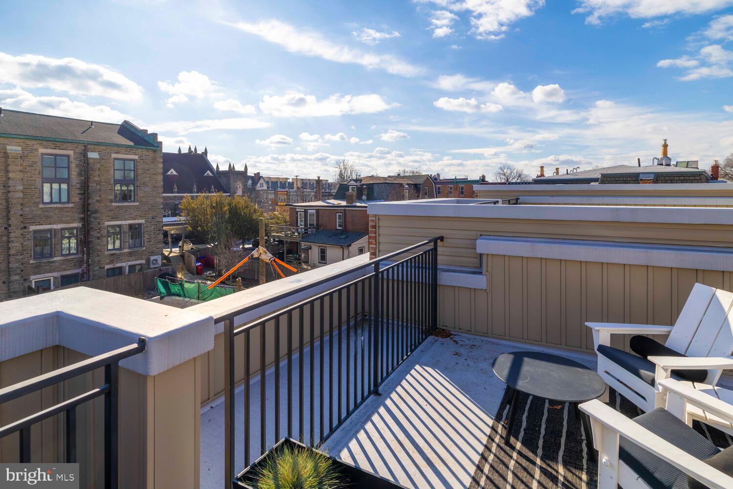 23 East Durham Street, Unit C2 Philadelphia, PA 19119 - Photo 30 of 40 a balcony with wooden floor outdoor seating and city view