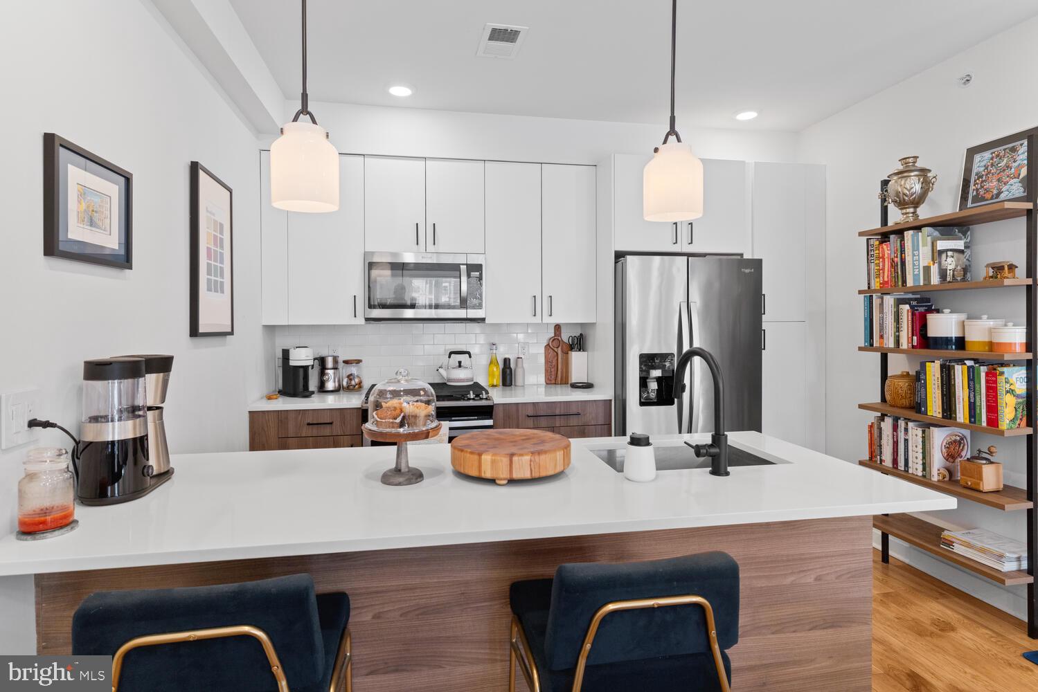 23 East Durham Street, Unit C2 Philadelphia, PA 19119 - Photo 3 of 40 a kitchen with a refrigerator a stove a sink and a dining table with wooden floor