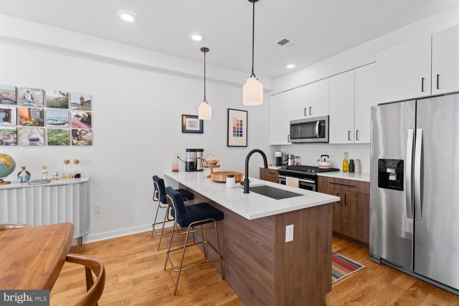 23 East Durham Street, Unit C2 Philadelphia, PA 19119 - Photo 5 of 40 a kitchen with stainless steel appliances granite countertop a sink a stove a refrigerator cabinets a dining table and chairs