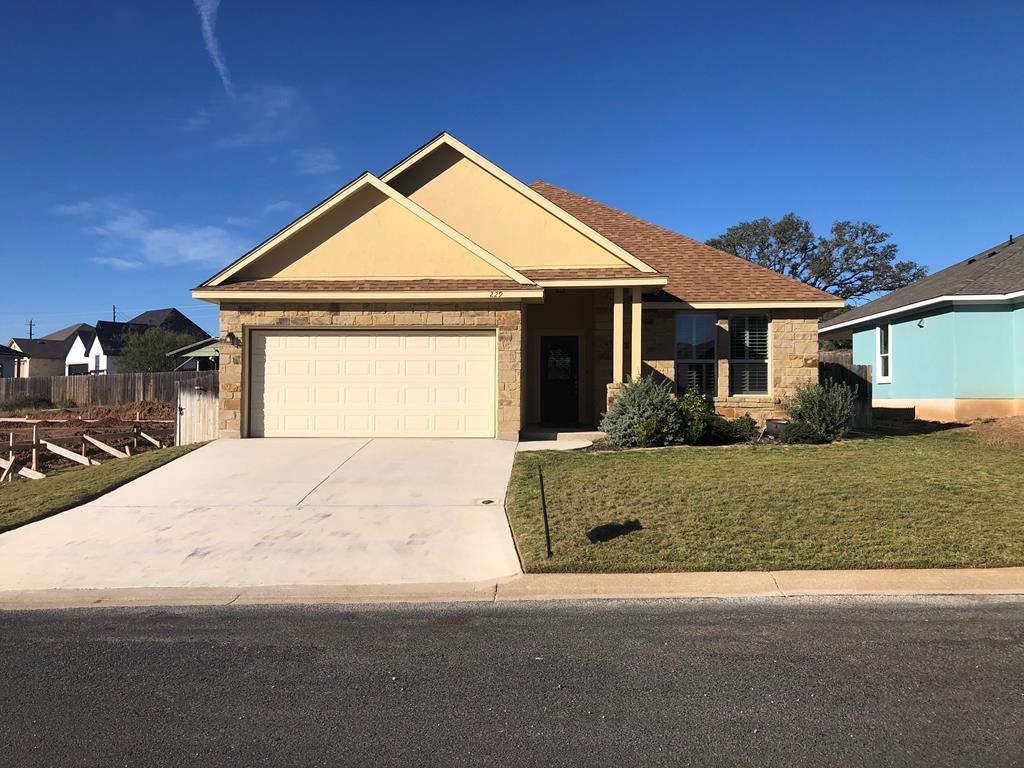 229 Riley Lane Fredericksburg, TX 78624 - Photo 2 of 16 a front view of a house with a yard and garage