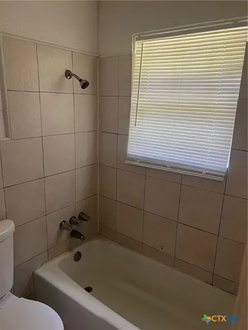 a bathroom with a bathtub and next to a window