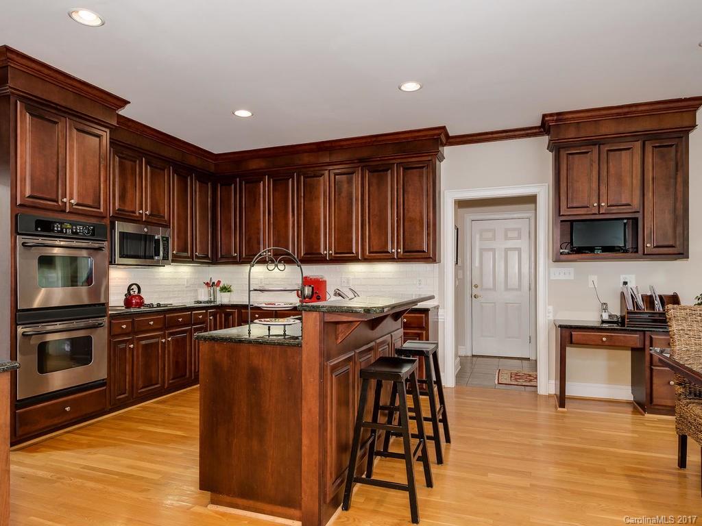 1415 Windy Ridge Road Charlotte, NC 28270 - Photo 9 of 24 a kitchen with stainless steel appliances granite countertop wooden cabinets a stove top oven a sink and dishwasher