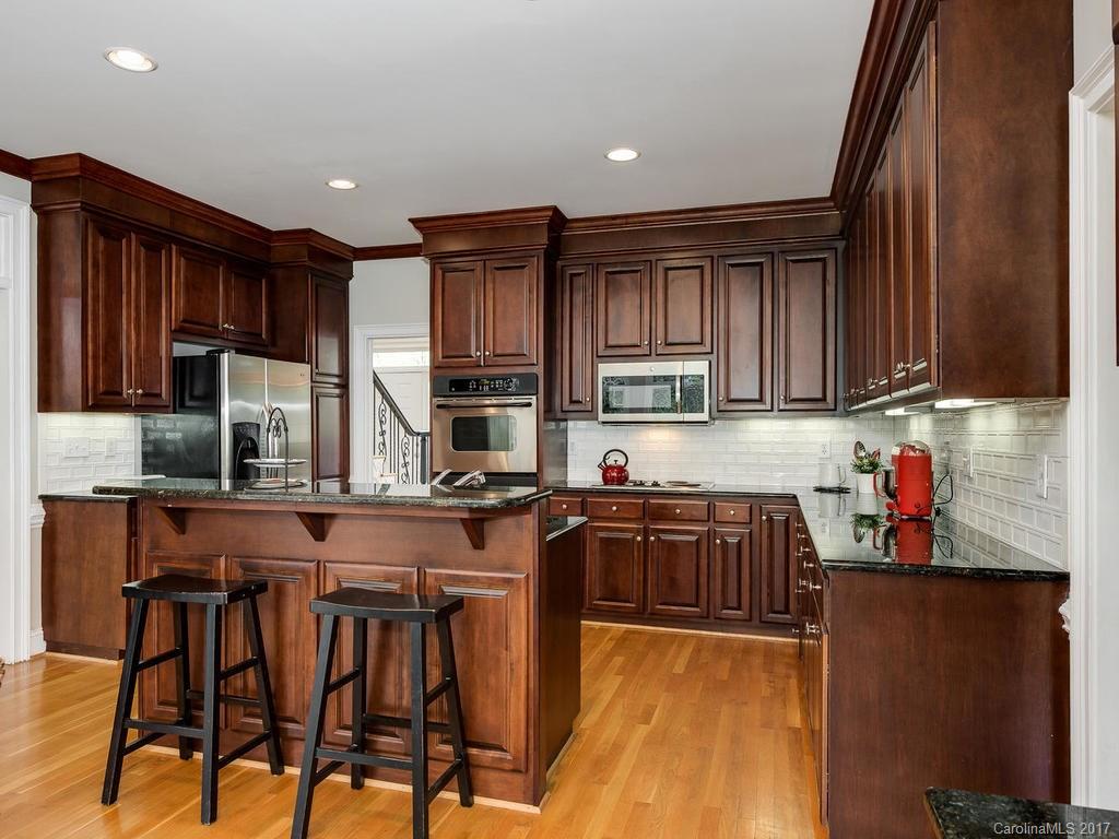 1415 Windy Ridge Road Charlotte, NC 28270 - Photo 10 of 24 a kitchen with stainless steel appliances granite countertop wooden cabinets a refrigerator a stove a sink and a microwave