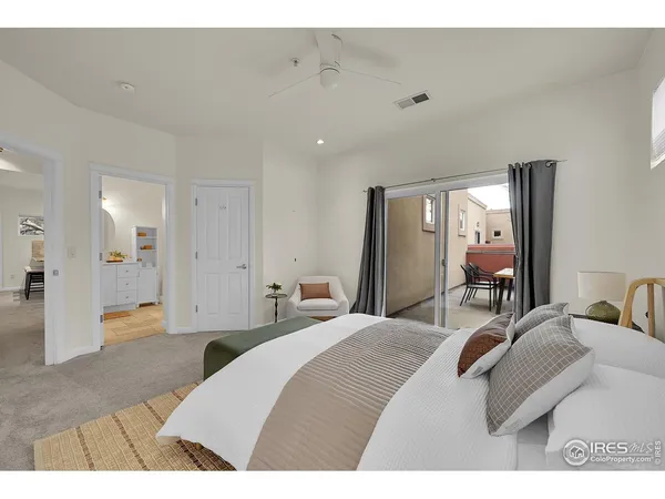 a bedroom with a bed a mirror and lamp