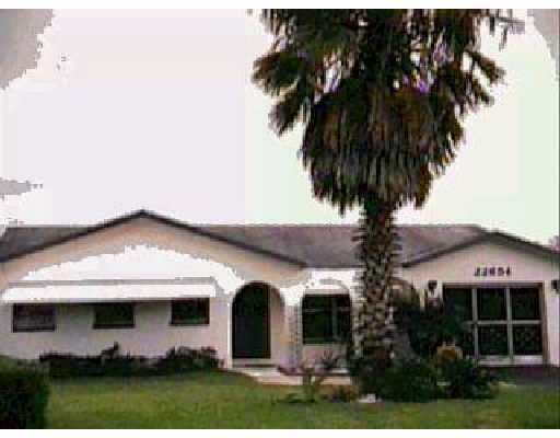 22654 Family Circle Boca Raton, FL 33428 - Photo 2 of 2 a front view of house with yard and palm tree