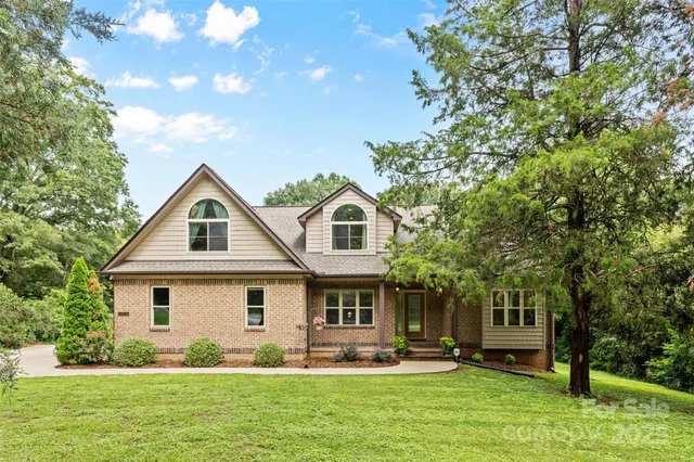 a front view of a house with a yard and trees