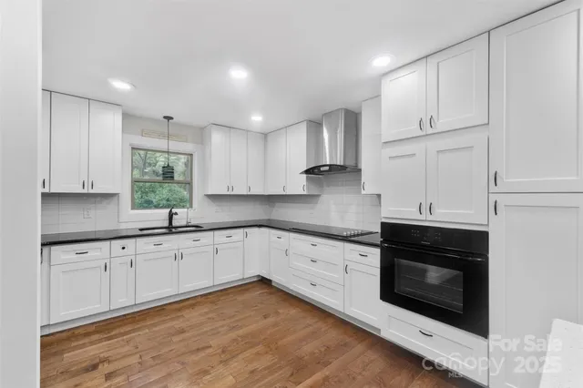 a kitchen with granite countertop white cabinets stainless steel appliances and a sink
