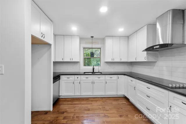a kitchen with granite countertop white cabinets white appliances a sink and a oven