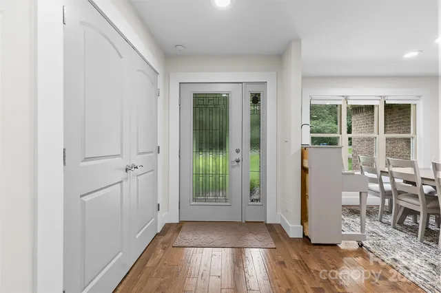 an entryway with wooden floor and windows