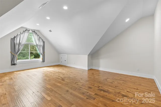 an empty room with wooden floor and a window