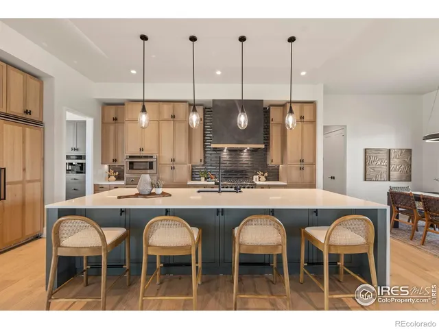 a kitchen with stainless steel appliances granite countertop a table chairs sink and oven