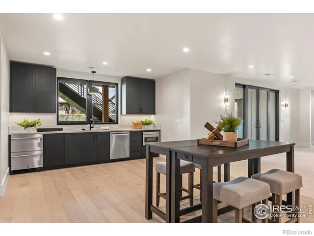 a kitchen with stainless steel appliances kitchen island granite countertop a sink cabinets and wooden floor