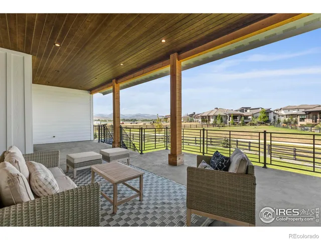 a living room with furniture and floor to ceiling windows