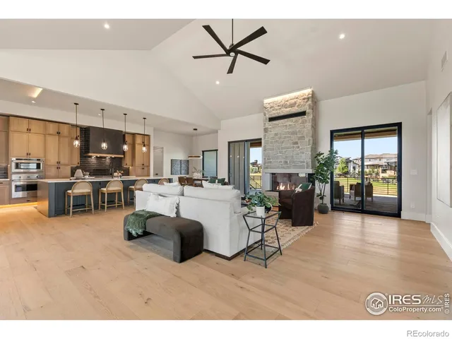 a living room with furniture kitchen view and a chandelier