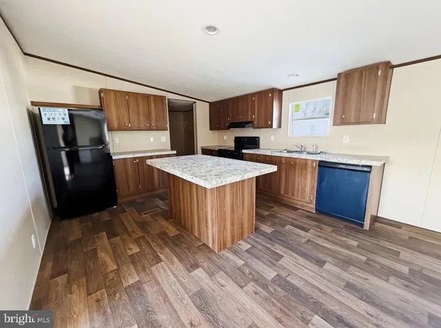 a kitchen with stainless steel appliances granite countertop a refrigerator a sink dishwasher a stove with wooden floor