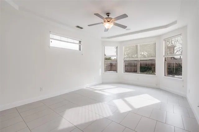 a view of an empty room with a window and a kitchen