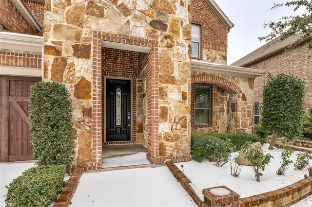 a view of a white building with a potted plant and a table and chair