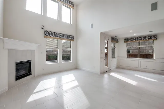 a view of an empty room with a window and fire place