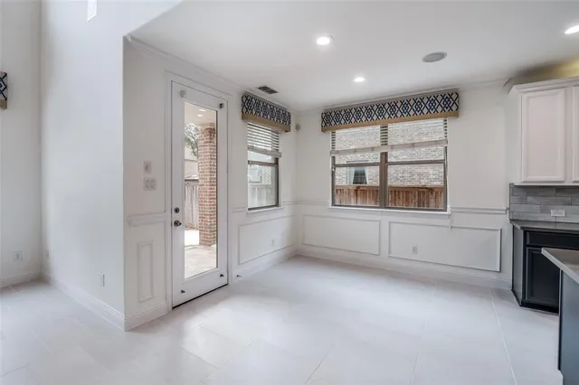 an empty room with windows and fireplace