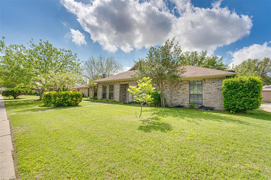 a front view of a house with a big yard and a large tree