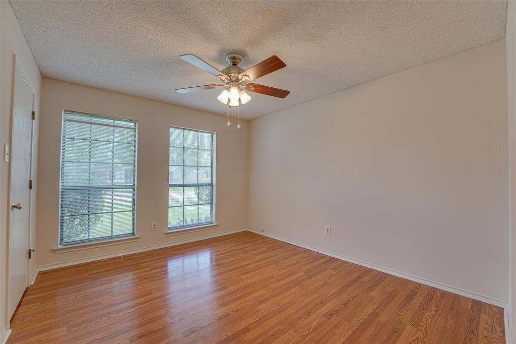 3410 Conlin Drive Rowlett, TX 75088 - Photo 15 of 27 an empty room with wooden floor chandelier fan and windows