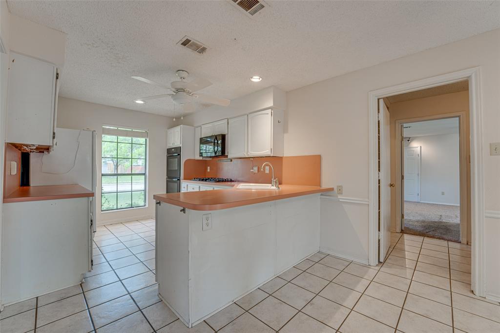 3410 Conlin Drive Rowlett, TX 75088 - Photo 8 of 27 a kitchen with stainless steel appliances granite countertop a sink and a refrigerator