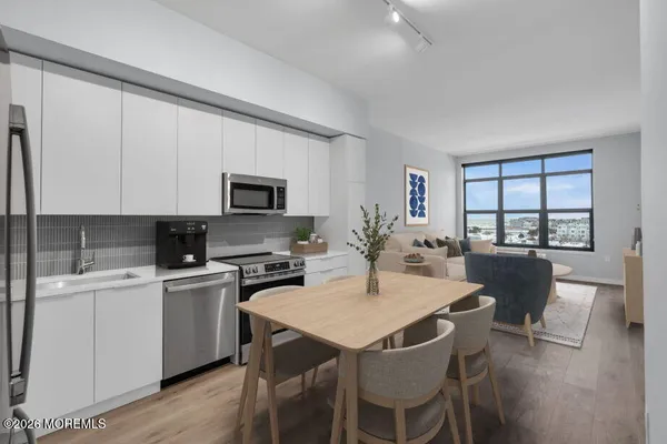 a kitchen with a dining table chairs and white appliances