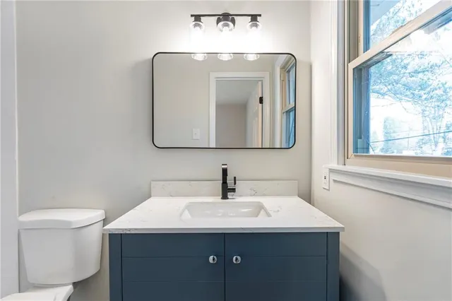 a bathroom with a toilet sink and mirror