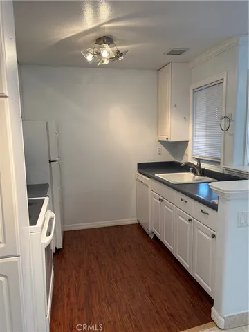 a kitchen with sink cabinets and wooden floor
